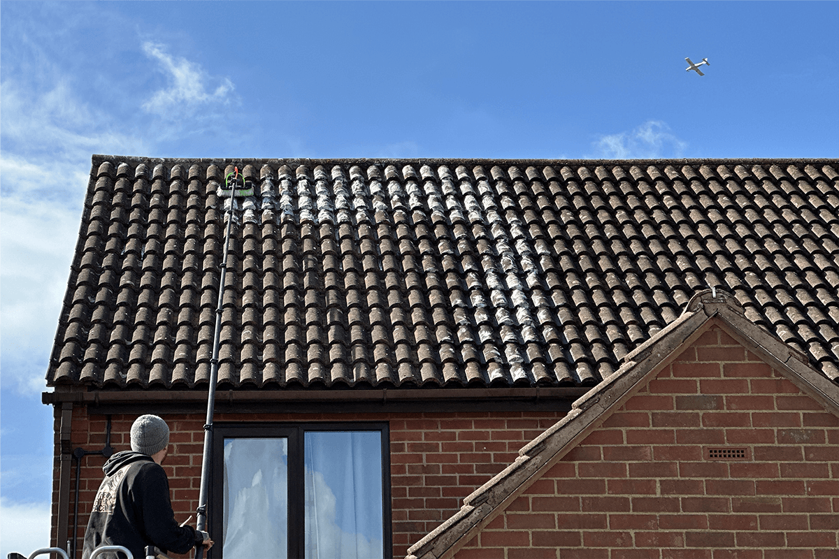 Heritage Roof Care specialist applying biocide treatment to roof tiles in Buckinghamshire